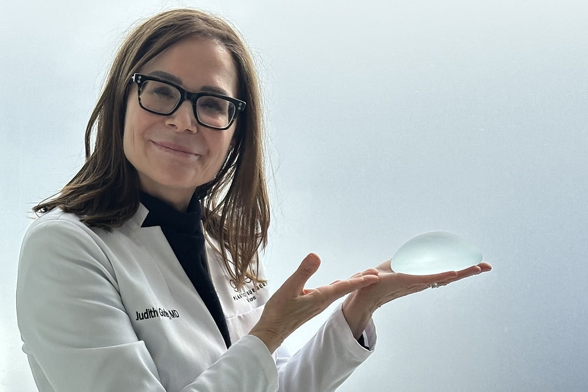 Doctor holding a silicone breast implant.