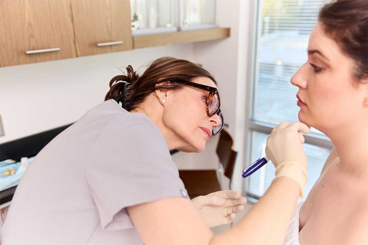 Medical professional assessing patient's facial features.