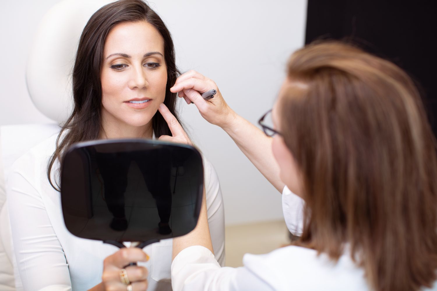 Smiling woman with curly hair, bright background.