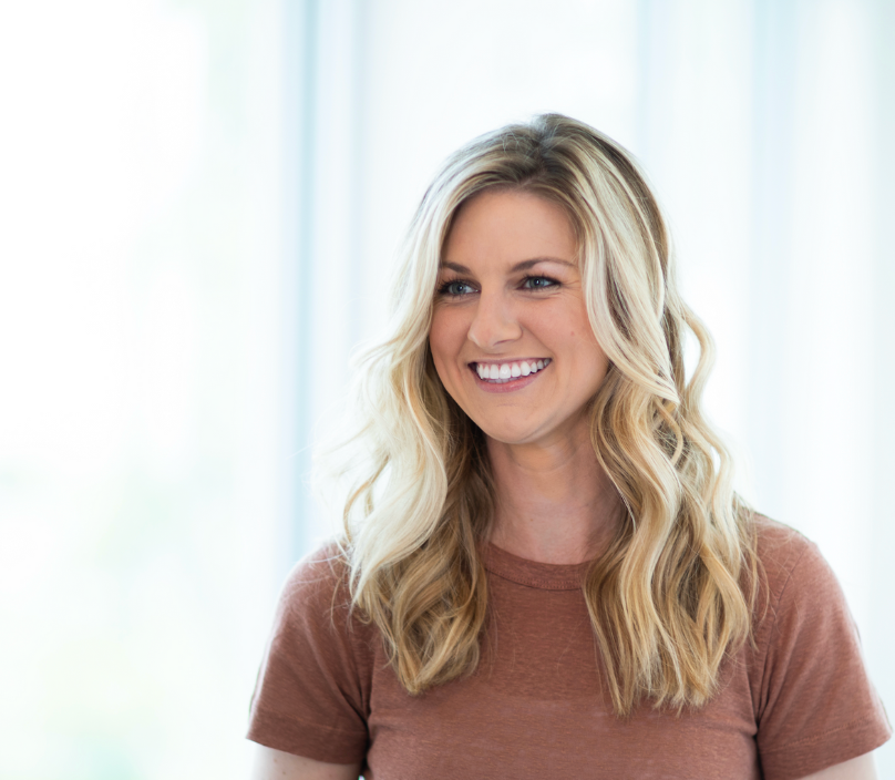 Smiling woman with long, wavy blonde hair.
