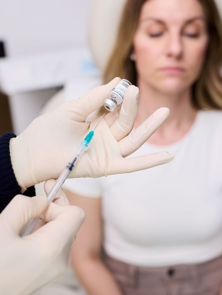 Administering vaccine to patient in clinical setting.