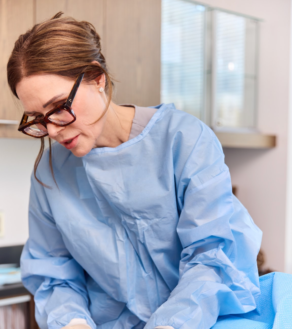 Medical professional in blue scrubs assisting.