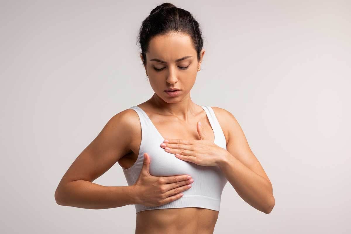 Woman checking herself for breast health.