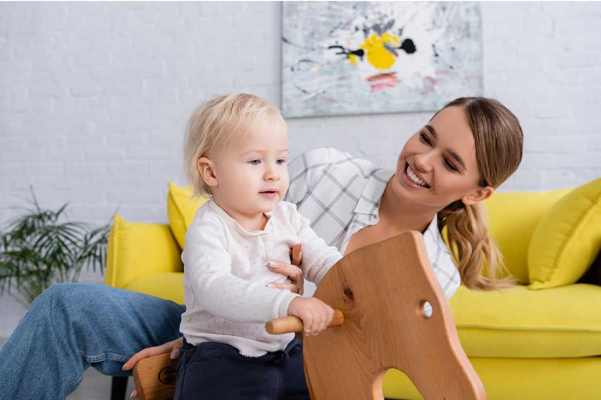 Mother and child playing together in a bright room.