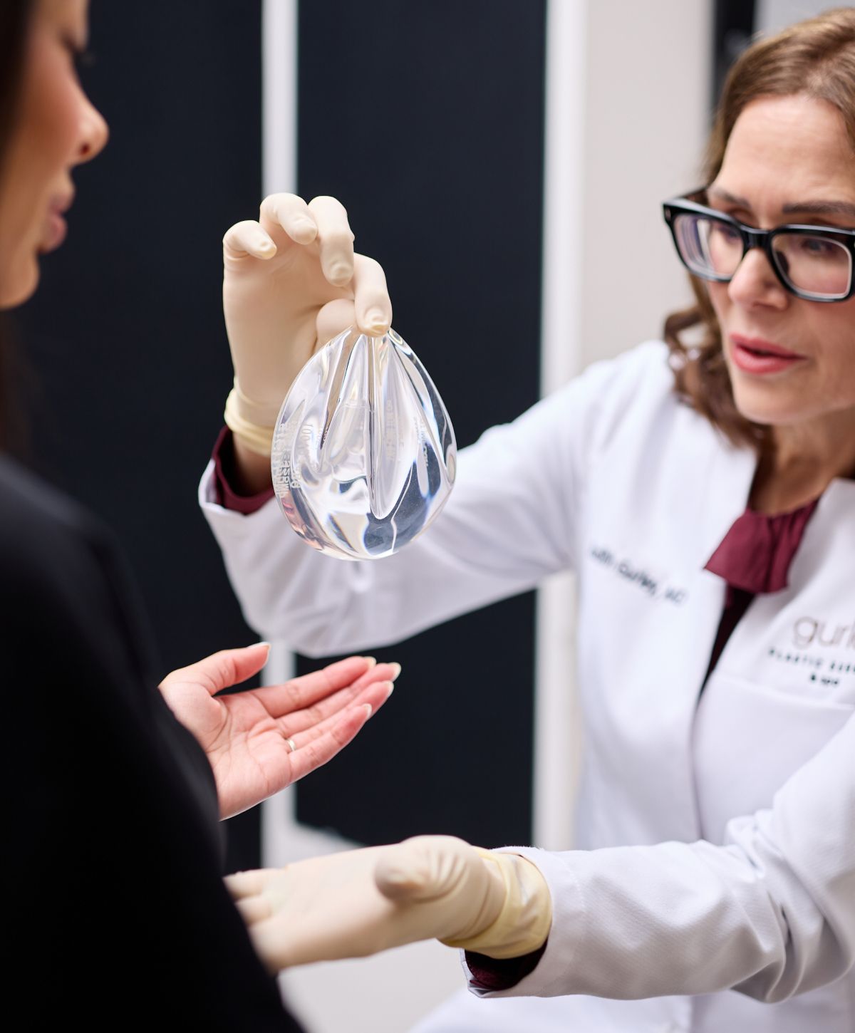 Surgeon demonstrating breast implant to patient.