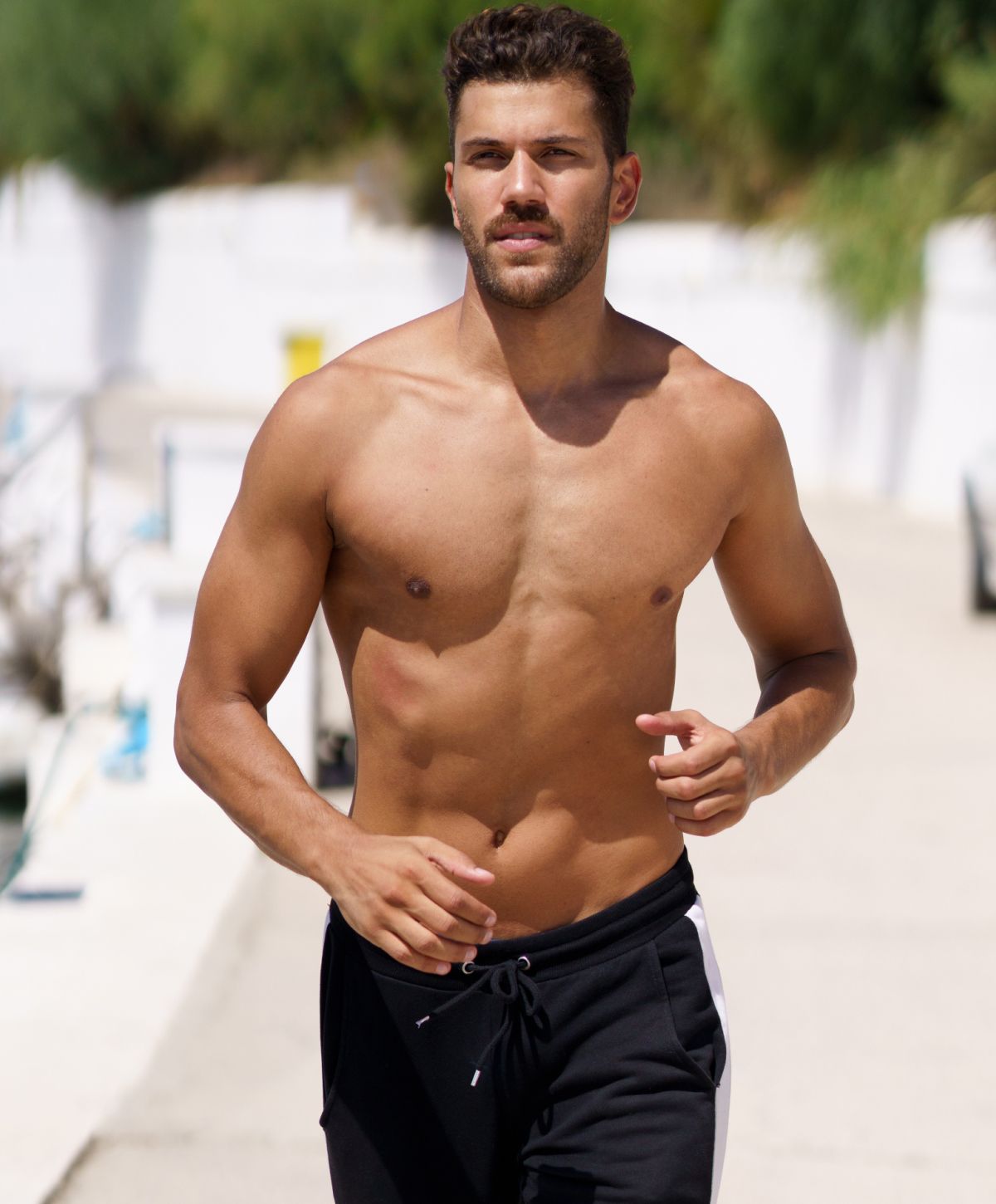 Man jogging on a sunny day by the water.