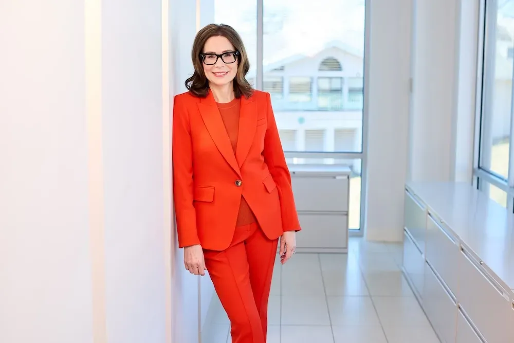 Professional woman in red suit, office setting.