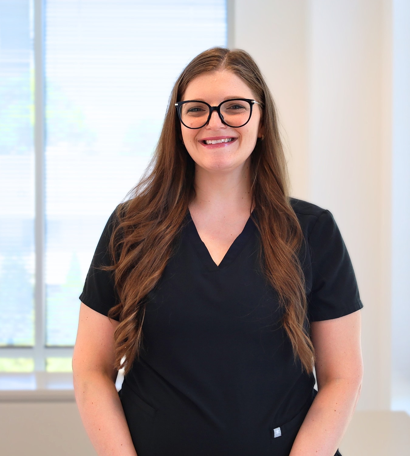 Smiling woman in black uniform indoors.