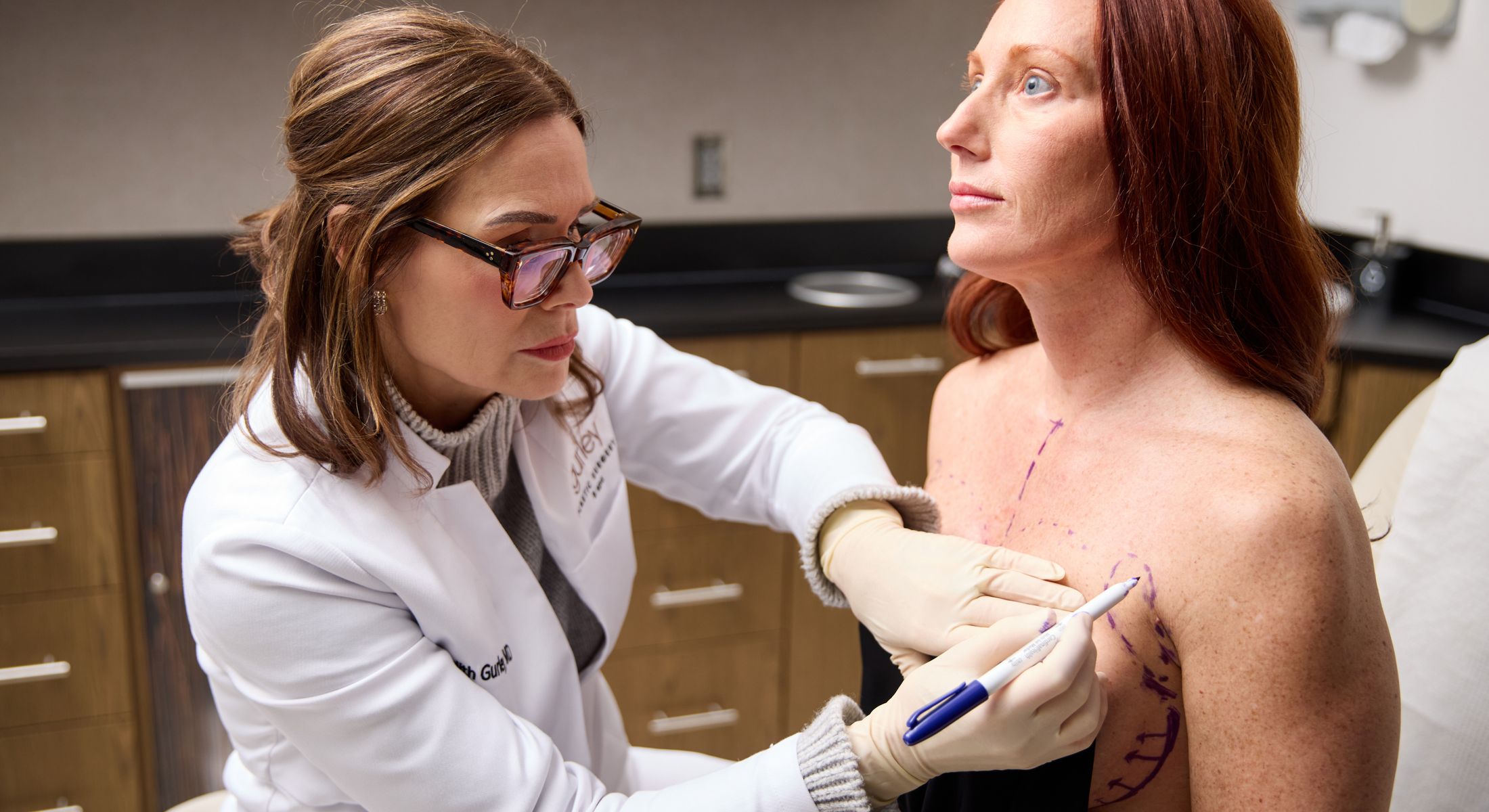 Medical professional marking patient’s skin for surgery.